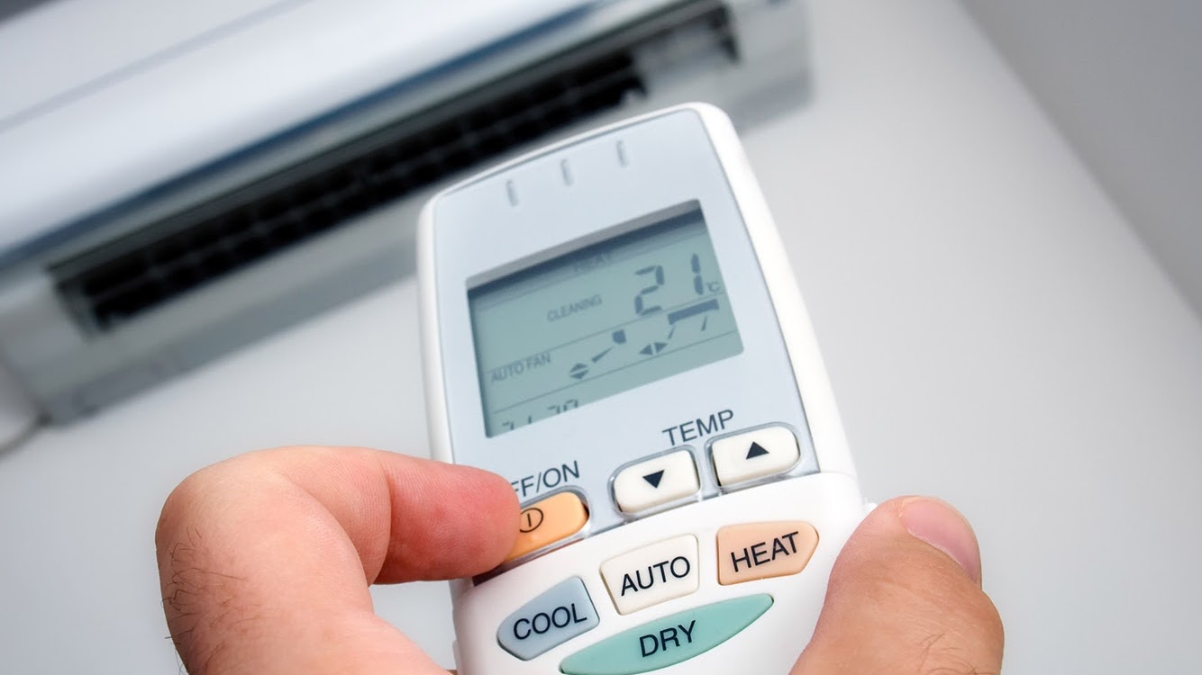 Mando de aire acondicionado ajustando la temperatura de una estancia